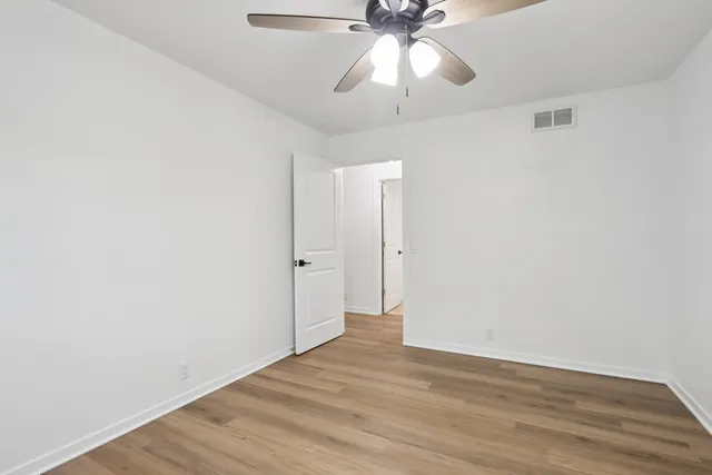 a view of an empty room with wooden floor