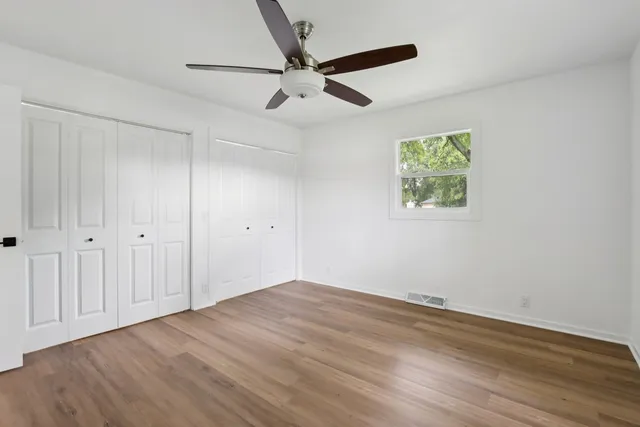 an empty room with a window and a ceiling fan