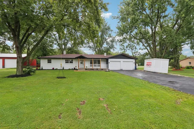 a front view of a house with a yard and trees