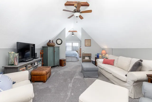 a living room with furniture a flat screen tv and a window