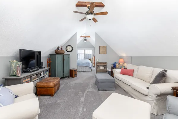 a living room with furniture a flat screen tv and a window