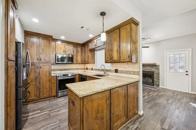 a kitchen with a refrigerator a sink and wooden floor