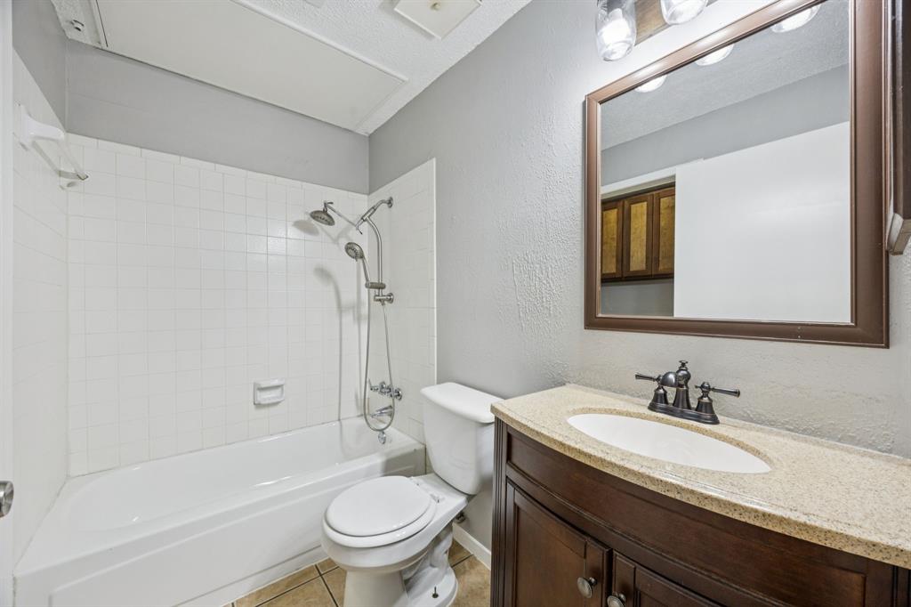 6814 Dolphin Circle Rowlett, TX 75088 - Photo 5 of 30 a bathroom with a granite countertop sink toilet and shower