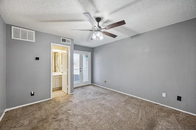 an empty room with closet and windows