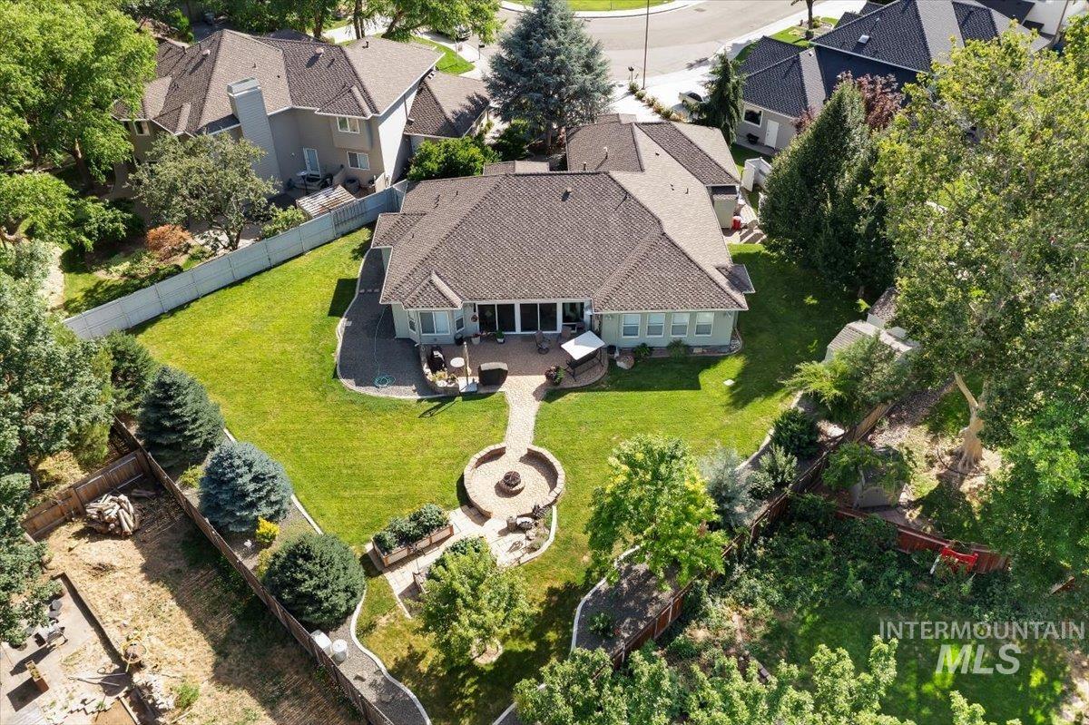5184 North Greyloch Way Boise, ID 83704 - Photo 25 of 32 Expansive green lawn with a circular paved patio featuring a built-in fire pit