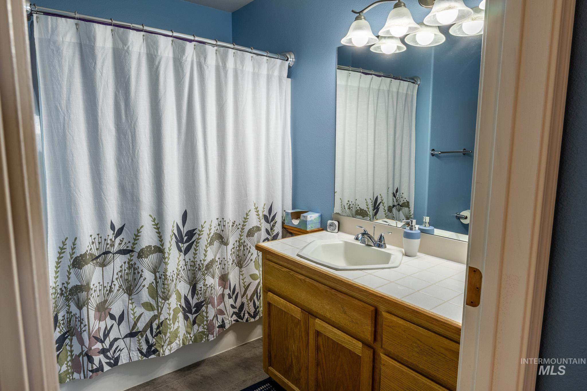 925 Hawthorne Street, Unit A Lewiston, ID 83501 - Photo 17 of 25 Bathroom featuring vanity, shower / bath combo with shower curtain, and a chandelier
