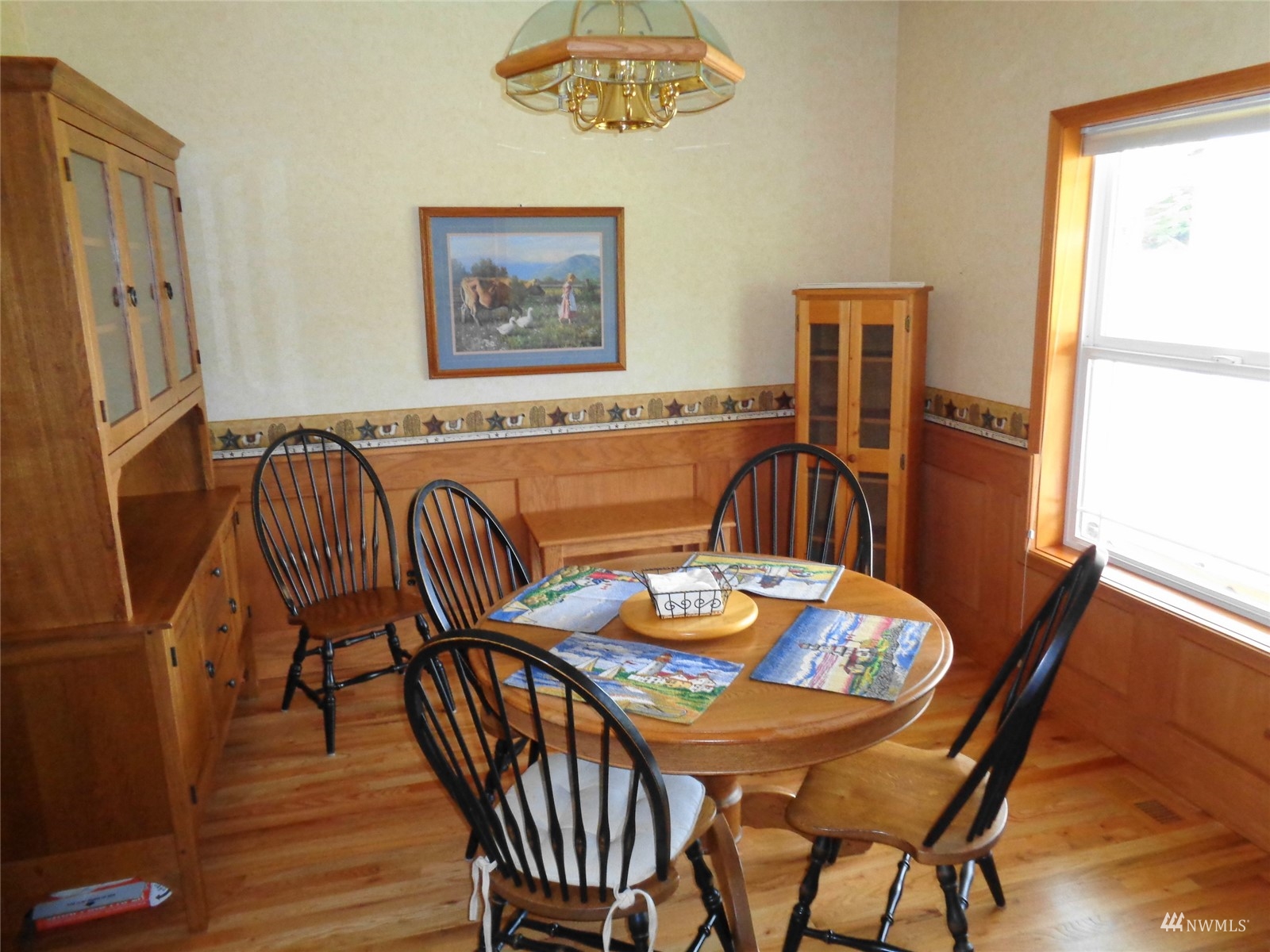 9517 185th Avenue Southwest Rochester, WA 98579 - Photo 17 of 28 a view of a dining room with furniture a chandelier and wooden floor