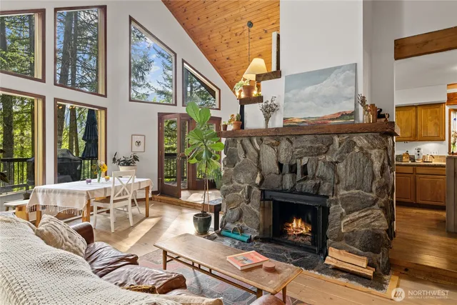a living room with furniture a fireplace and a floor to ceiling window