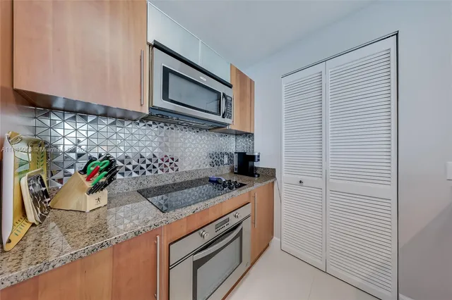 a kitchen with stainless steel appliances granite countertop a sink stove and cabinets