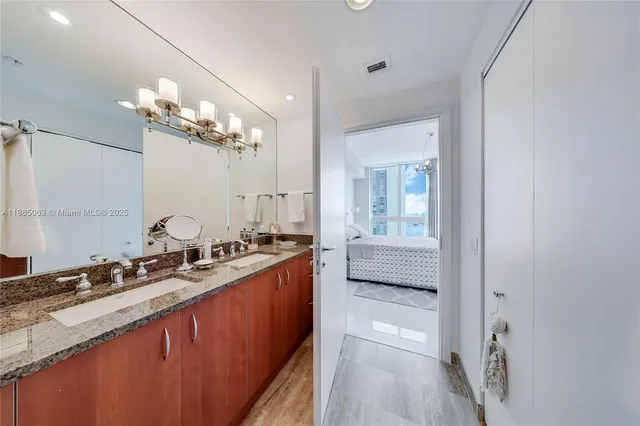 a bathroom with a double vanity sink a toilet and a mirror