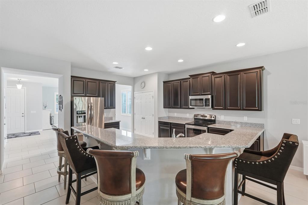 1457 Osprey Ridge Drive Eustis, FL 32736 - Photo 11 of 54 a kitchen with a table chairs a sink and a refrigerator