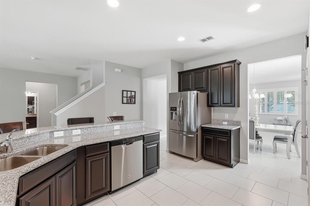 1457 Osprey Ridge Drive Eustis, FL 32736 - Photo 12 of 54 a kitchen with stainless steel appliances granite countertop a sink stove and refrigerator