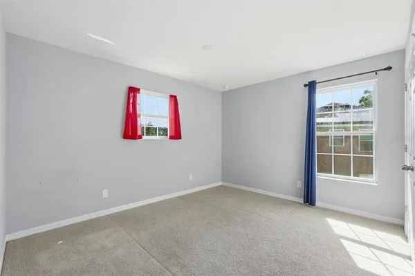 an empty room with floor to ceiling windows and a ceiling fan