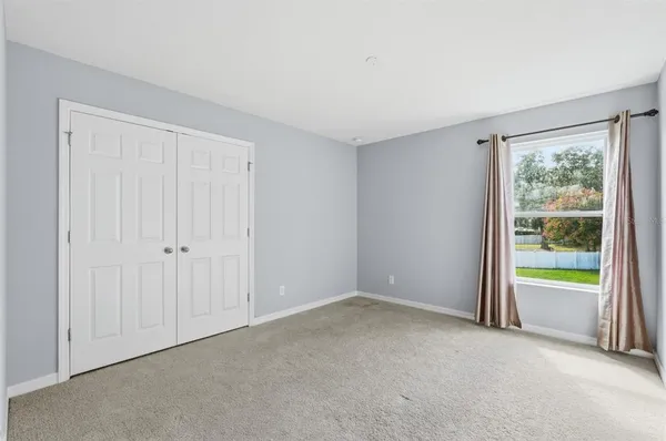a spacious bedroom with a bed and a window