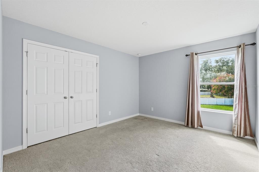 1457 Osprey Ridge Drive Eustis, FL 32736 - Photo 30 of 54 an empty room with floor to ceiling windows and a ceiling fan