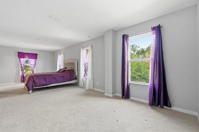 a spacious bedroom with a bed and a window