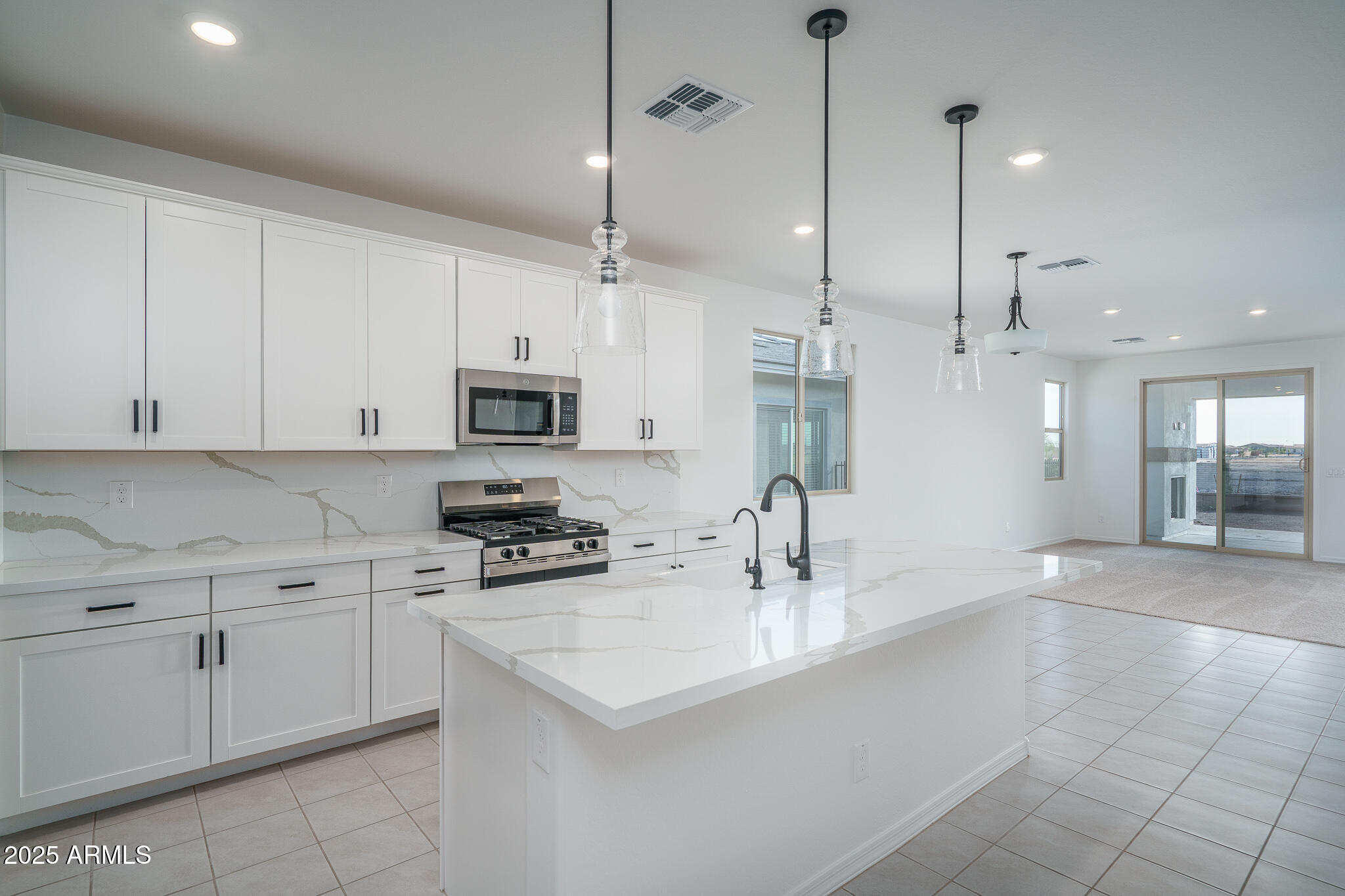 20607 West Rancho Drive Buckeye, AZ 85396 - Photo 4 of 32 a kitchen with stainless steel appliances kitchen island granite countertop a sink a stove and cabinets