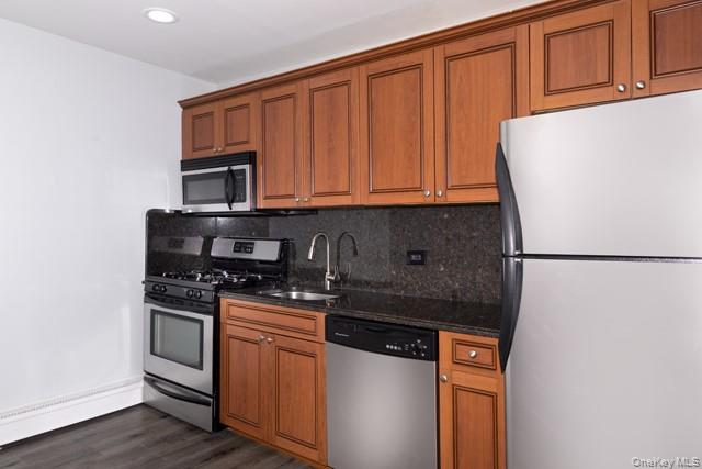 100 Friendly Court Avenue, Unit FC60 Babylon, NY 11704 - Photo 2 of 7 a kitchen with granite countertop a refrigerator stove and microwave