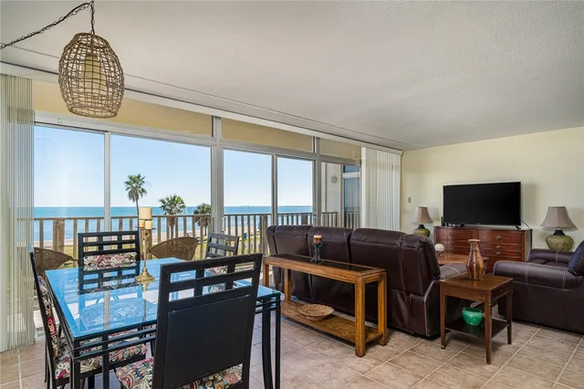 a living room with furniture a flat screen tv and a floor to ceiling window