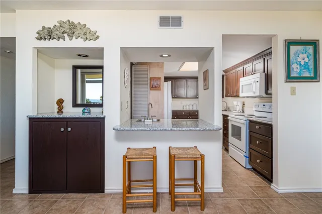 a kitchen with stainless steel appliances a stove refrigerator and cabinets