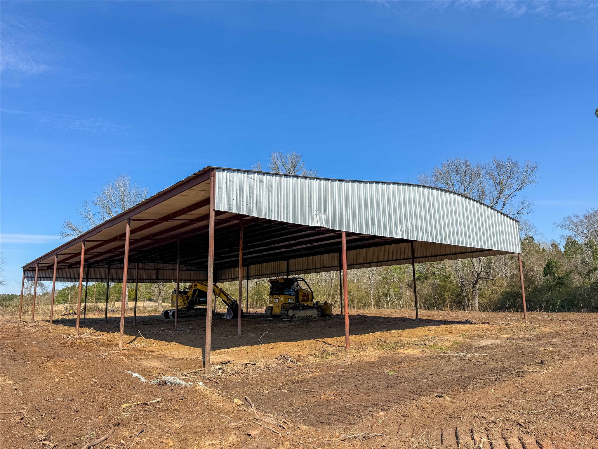 4 County Road 2780 Colmesneil, TX 75938 - Photo 4 of 50 a view of a chair and table and chairs under an umbrella
