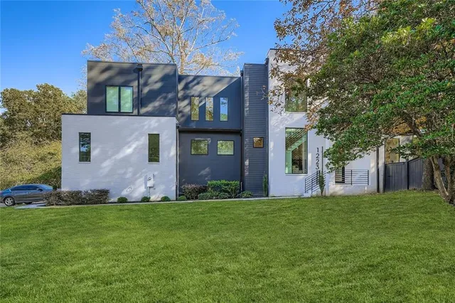 a view of a house with a big yard and large trees
