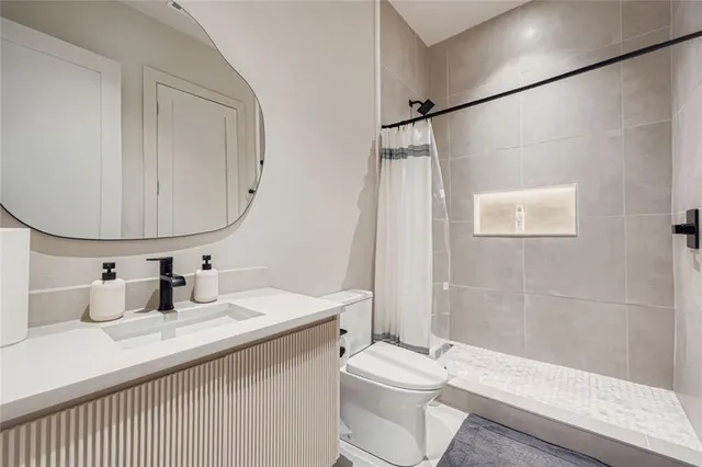 a bathroom with a sink a toilet and shower