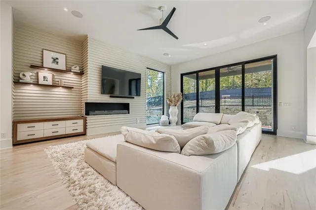 a living room with furniture large window and a flat screen tv