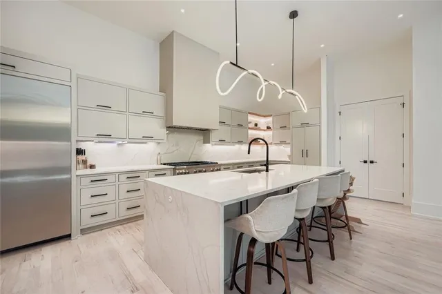 a kitchen with stainless steel appliances a stove a sink a island with wooden floor and cabinets