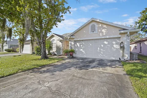 a view of a big house with a big yard and large tree