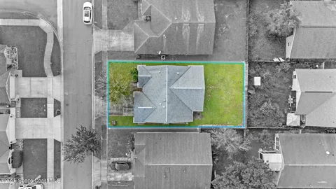 an aerial view of a house with a yard