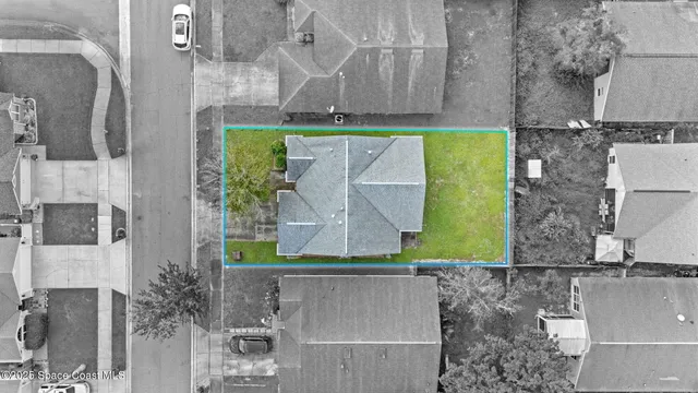 an aerial view of a house with a yard