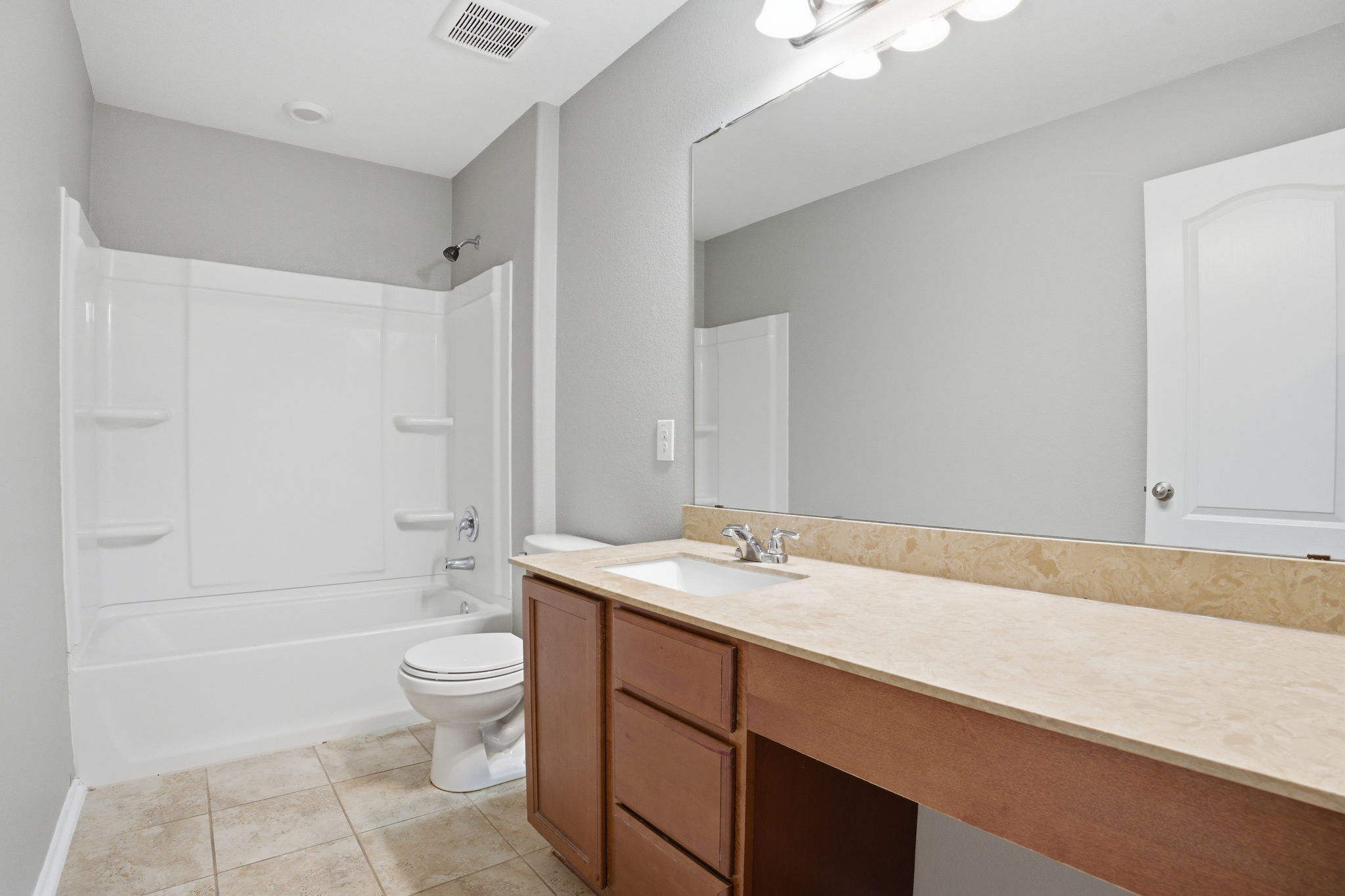 670 Landon Samuel Loop Pflugerville, TX 78660 - Photo 17 of 22 Full bathroom featuring a white tub/shower combination, a toilet, a vanity with a light-colored countertop, and tile flooring
