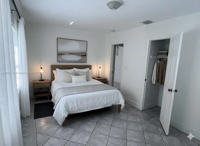 an empty room with a kitchen and wooden floor