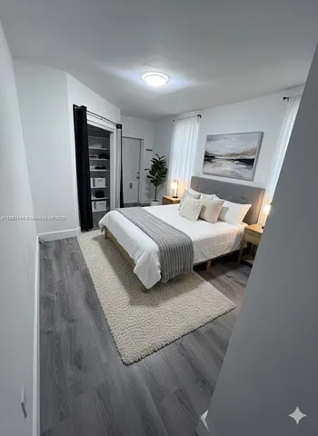 an empty room with wooden floor and window