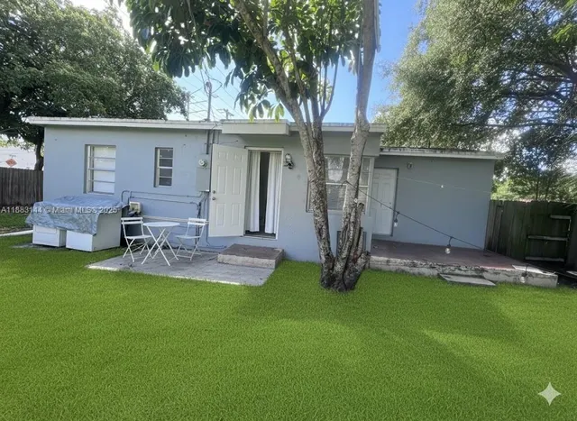 a backyard of a house with table and chairs