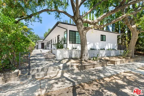 a front view of a house with a tree