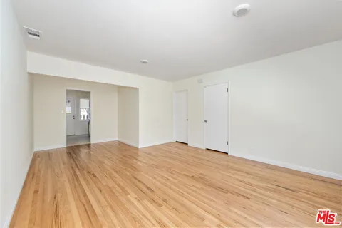 a view of empty room with wooden floor