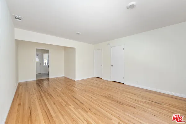 a view of empty room with wooden floor