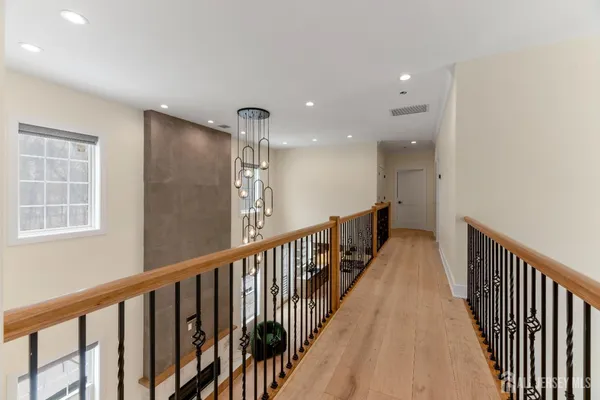 a view of a hallway with wooden floor and windows