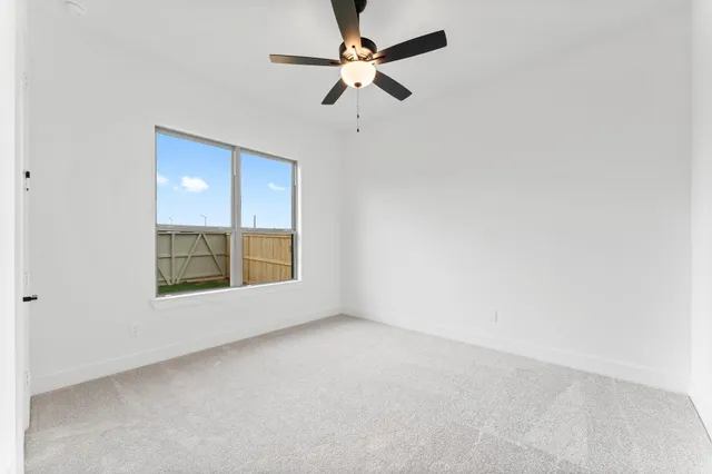 an empty room with a window and a fan