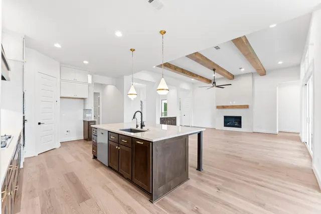 a kitchen with stainless steel appliances granite countertop a sink a stove and a wooden floors