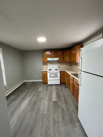 a kitchen with wooden floors and white appliances