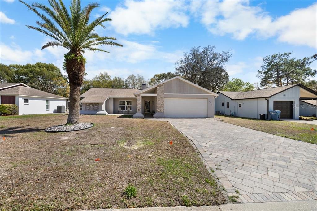 4498 Plumosa Street Spring Hill, FL 34607 - Photo 24 of 24 a front view of a house with a yard and garage