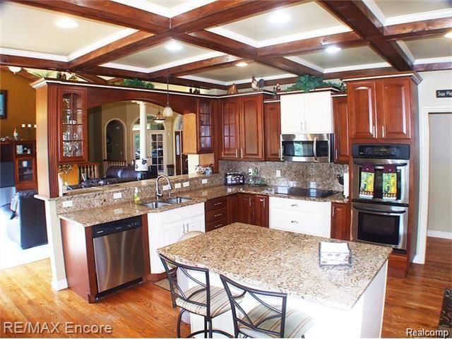 8629 Sashabaw Road Clarkston, MI 48348 - Photo 10 of 34 Coffered ceiling in kitchen with an abundance of recessed lights, granite, stainless and hardwood.