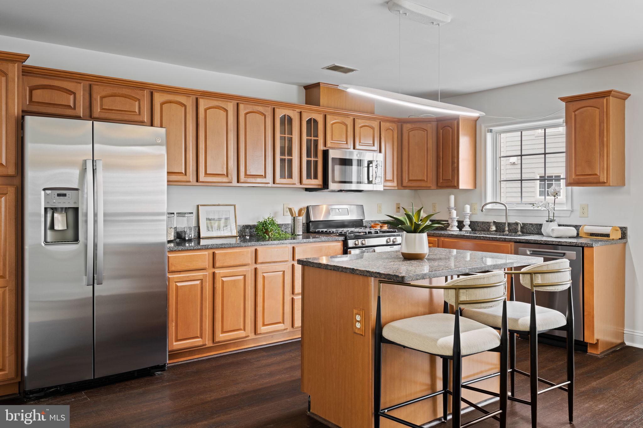 2341 Wallace Street, Unit B Philadelphia, PA 19130 - Photo 16 of 45 a kitchen with stainless steel appliances granite countertop a refrigerator a sink dishwasher a stove a dining table and chairs with wooden floor