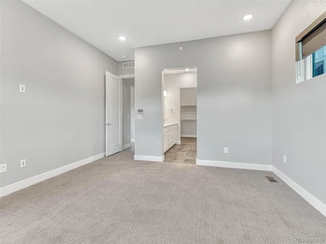 an empty room with windows and entrance to other room