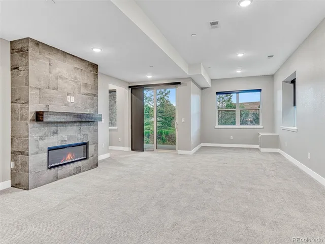 a view of an empty room with a fireplace and a window