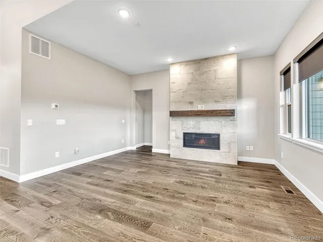 a view of an empty room with a fireplace and a window