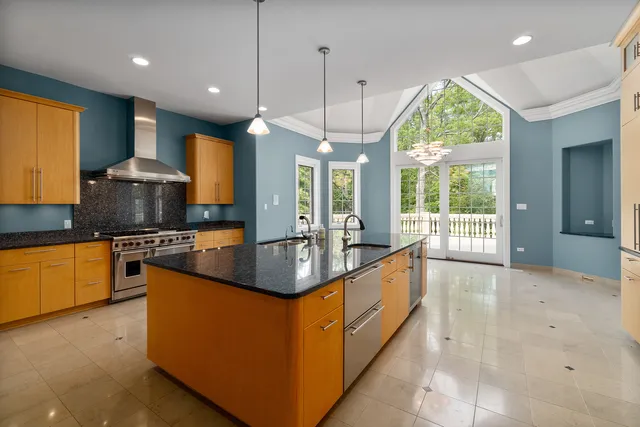 a kitchen with stainless steel appliances granite countertop a stove a sink and a refrigerator
